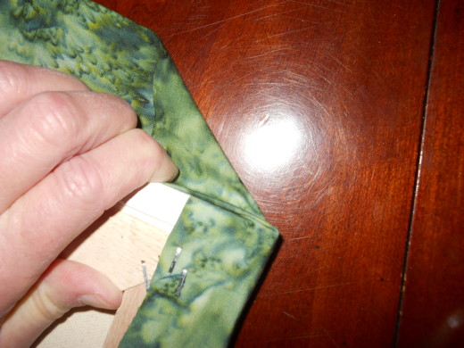 Fold the fabric on the short edges into a mitered corner
